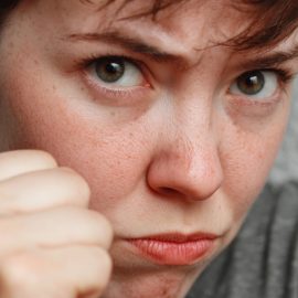 An offended woman putting up her fist illustrates the importance of the second agreement: Don't take anything personally