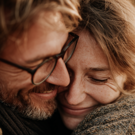 A man and woman hugging and smiling because they're in love