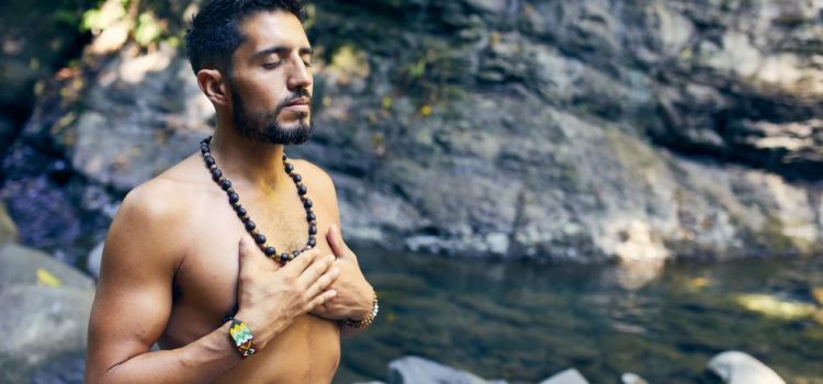 man doing yoga in a forest