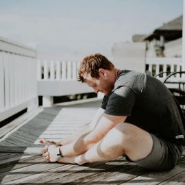 man doing yoga on porch