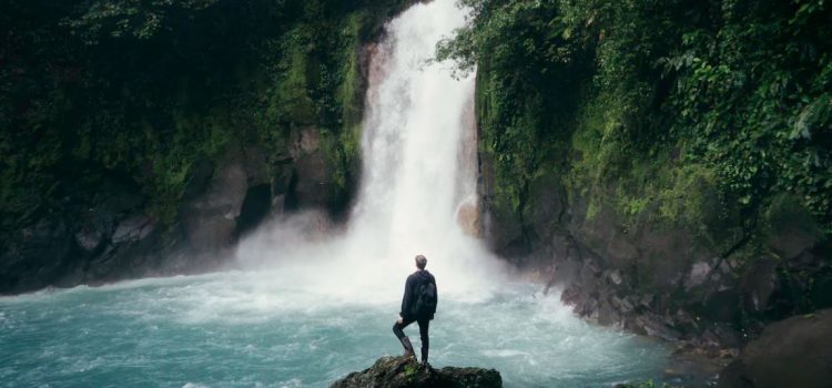 man in front of waterfall