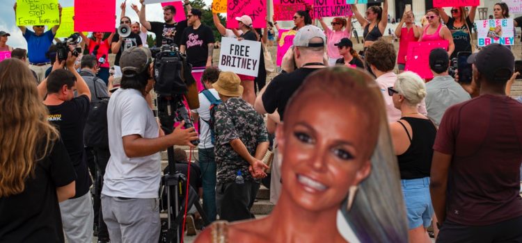 A cardboard cutout of Britney Spears in front of many people protesting outside for the Free Britney Movement.