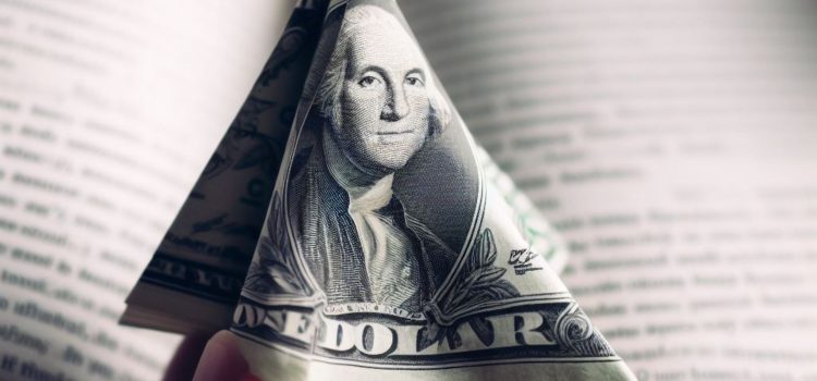 A dollar shaped as a triangle in front of an open book.