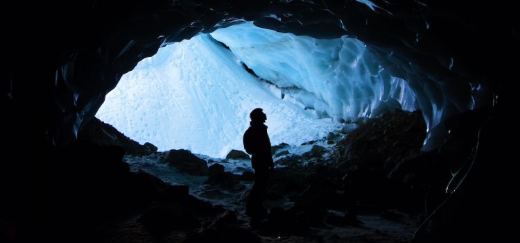 A silhouette of person underground in an ice cave.