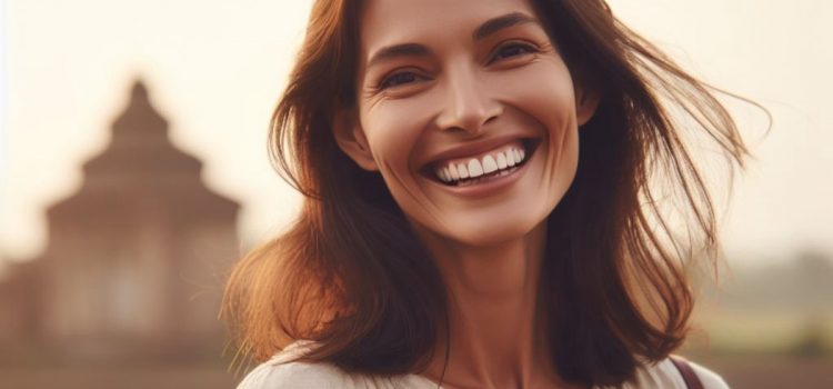 A smiling woman in front of a large building who's happy from doing self-help for low mood.