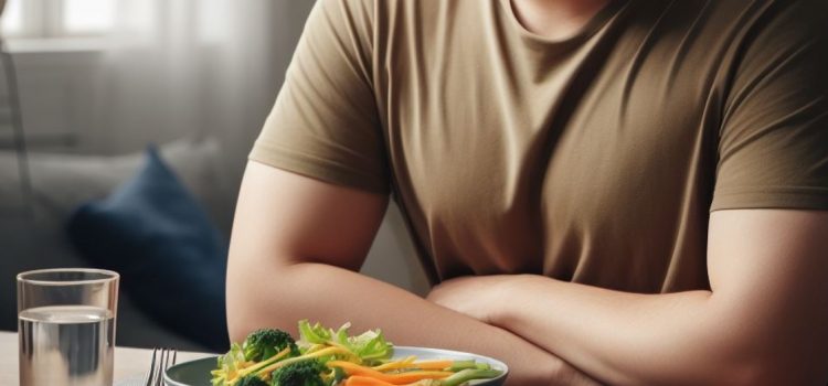 A man sitting in front of a plate of veggies during an intermittent fasting length.