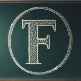 A giant "F" written on a chalkboard in a classroom.