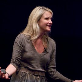 Mel Robbins giving a speech on a stage.