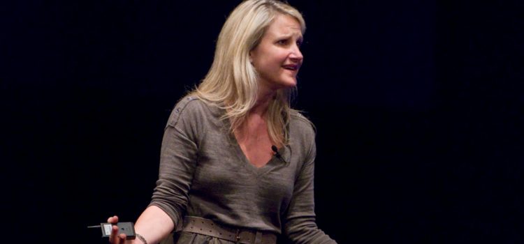 Mel Robbins giving a speech on a stage.