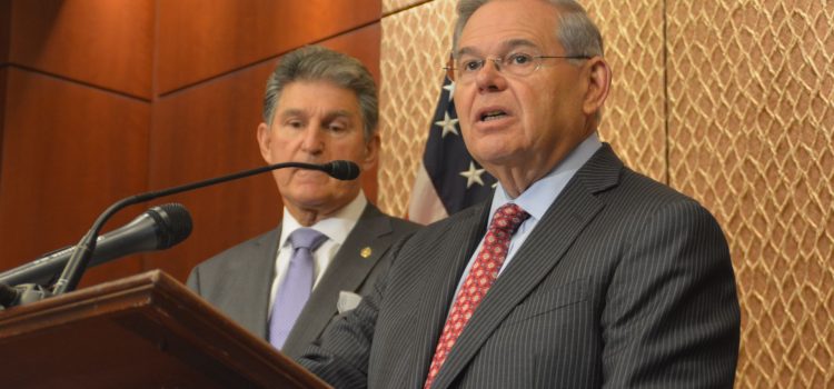 Senator Robert Menendez speaking at a press conference in front of a microphone.