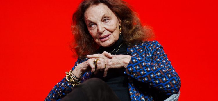 Fashion designer Diane von Fürstenberg sitting against a red background.