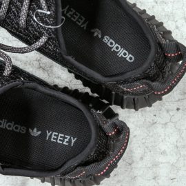 A pair of black Yeezys with the logo on the inside, made from the Kanye West-Adidas contract..