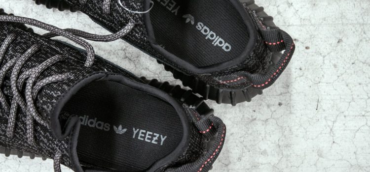 A pair of black Yeezys with the logo on the inside, made from the Kanye West-Adidas contract..