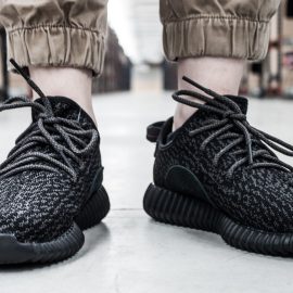 A pair of black Yeezy shoes in a manufacturing building.