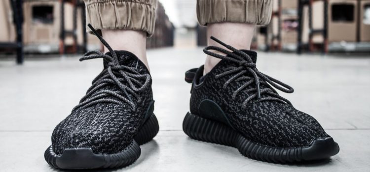 A pair of black Yeezy shoes in a manufacturing building.