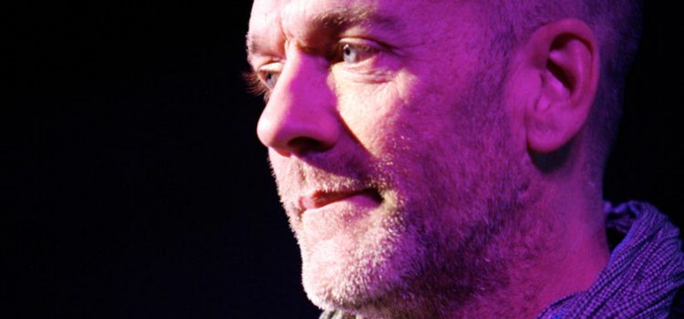 Michael stipe on stage looking to the left thoughtfully