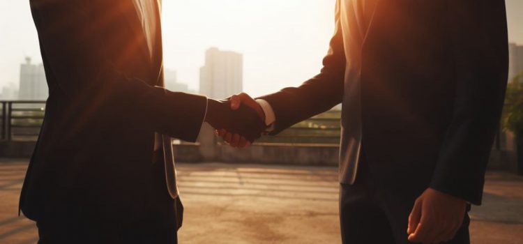 Two men in suits shaking hands outside, showing how to hire the right person.