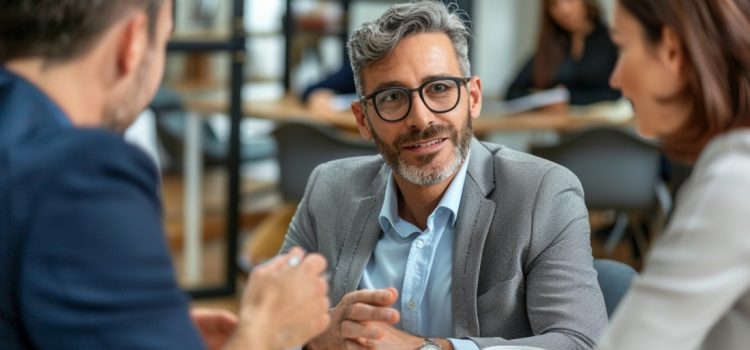 A manager in a gray suit talking to employees and showing how to be a good CEO.