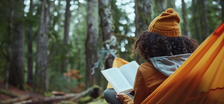 The Nature Fix: Book Overview (Florence Williams) A girl reading a book while in a hammock in the forest