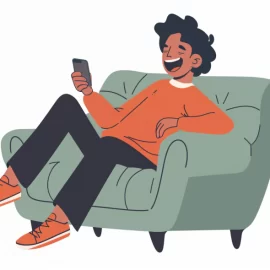 A man laughing at media on his phone while he sits in a chair