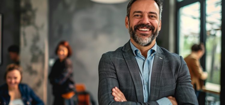 Find a Career That Makes a Difference: Ask These 3 Questions A smiling man at work with coworkers behind him illustrates a career that makes a difference