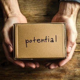 A person holding a cardboard box to tap into their potential, with the word "potential" written on it