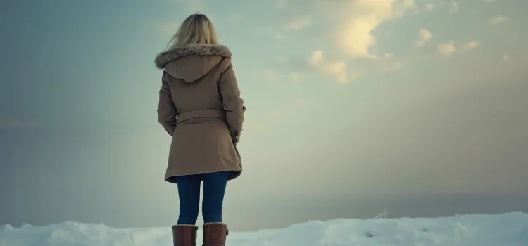 How to Overcome Toxic Shame: 3 Steps to Joy (John Bradshaw) A woman seen from the back standing in show and looking into the clouds illustrates how to overcome toxic shame