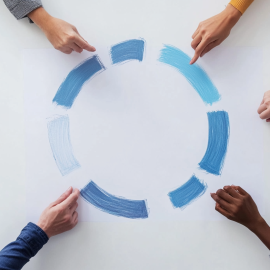 Employees' hands surrounding a circle on a whiteboard, representing the agile business strategy