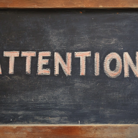 The word "Attention" on a chalkboard, as part of a lesson teaching what attention means