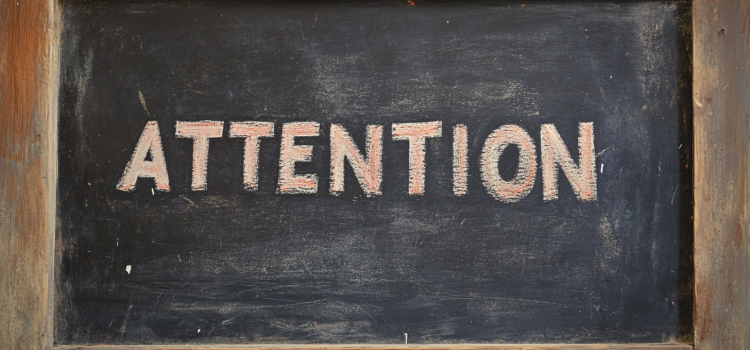 The word "Attention" on a chalkboard, as part of a lesson teaching what attention means