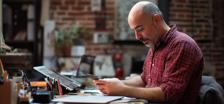 Are Distractions Good? The Pros and Cons of Losing Focus A man texting on his phone at work, showing that distractions are good sometimes