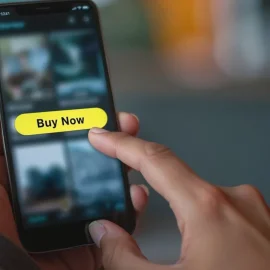 A person clicking the "Buy Now" button on the screen of a phone illustrates how to convert leads into sales