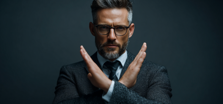 A man in a suit crossing his arms in the shape of an X to signify he is denying something