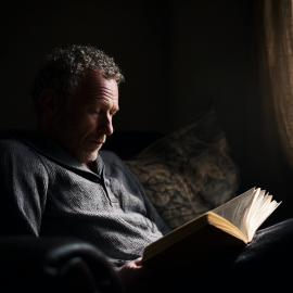A man reading a book in the dark