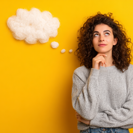 A woman pondering with a thought bubble in front of a yellow background