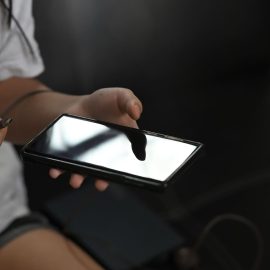 A girl unplugging her cell phone from its charger