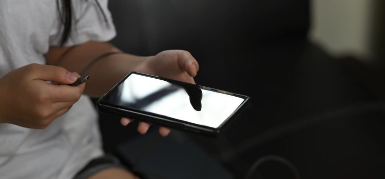 A girl unplugging her cell phone from its charger