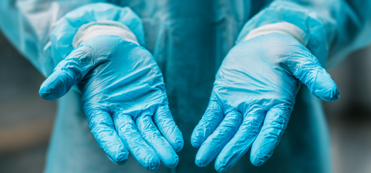 An up-close shot of a surgeon wearing a gown and gloves
