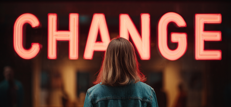 A woman looking at a neon sign that reads "CHANGE"