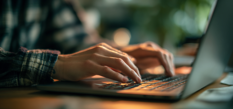 Una persona escribiendo en el teclado de un portátil