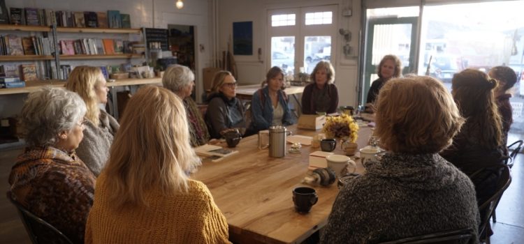 The Let Them Theory: 23 Book Club Questions & Exercises Um clube do livro formado por várias mulheres sentadas ao redor de uma mesa em uma livraria discutindo um livro