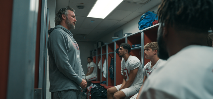 You Win in the Locker Room First: Book Overview & Takeaways Um técnico conversando com jogadores de futebol no vestiário