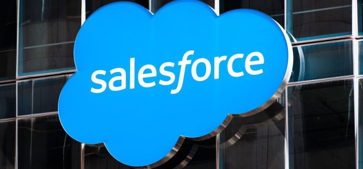 A Salesforce sign hanging on a building with glass windows