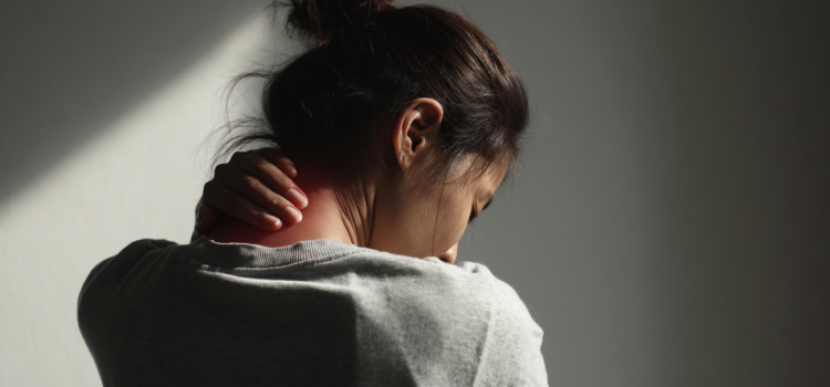 A woman holding the back of her neck because she's suffering from chronic pain