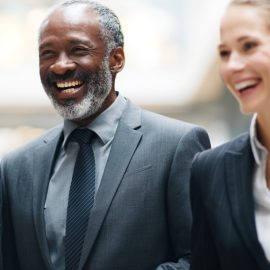 Professional colleagues (three men and one woman) smiling and laughing together