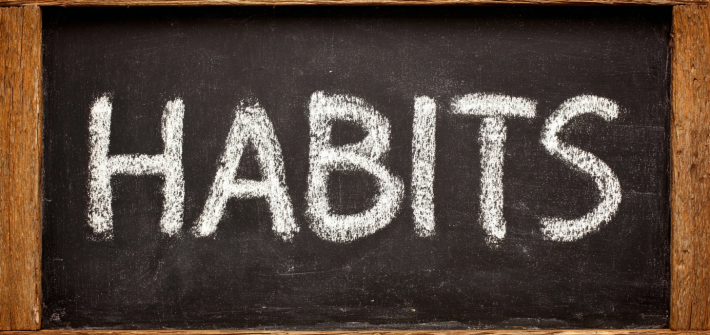 The word "HABITS" written on a chalkboard
