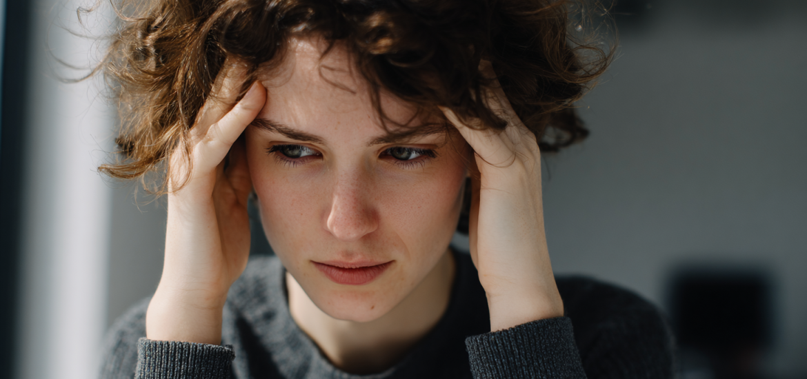 A stressed out person holding their head