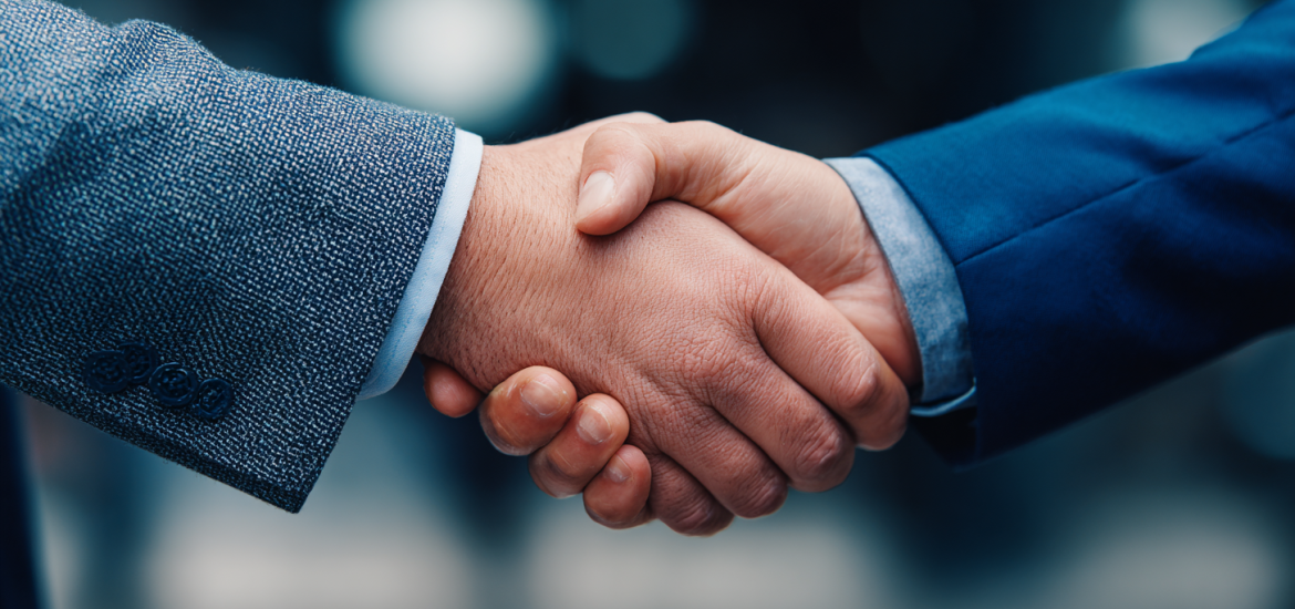 Two people in business suits shaking hands to build a professional network