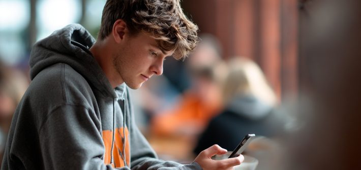 A student using their phone at school to use apps that make you smarter