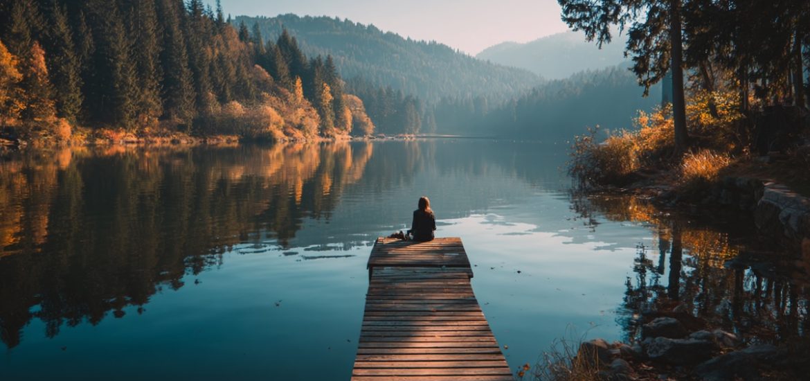 A woman on a dock at a lake illustrates the importance of understanding what survival mode is and how to get out of it